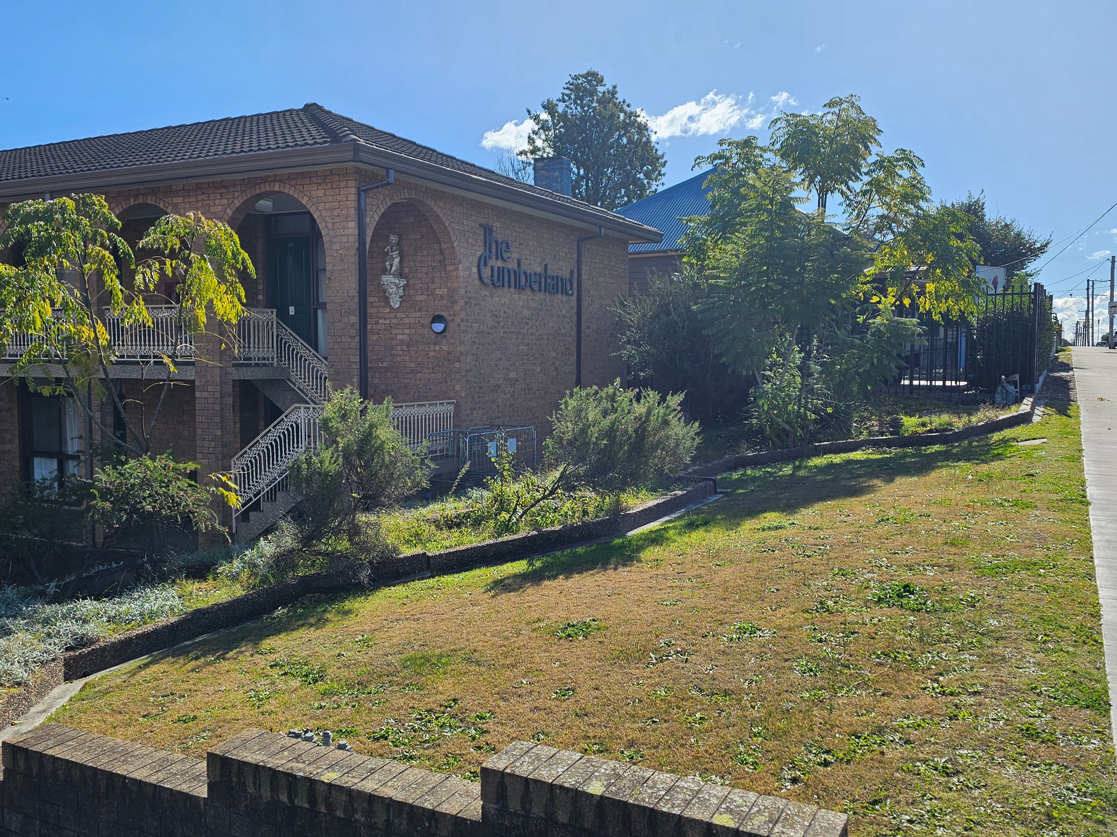 Exterior view of The Cumberland building facade and landscaped lawn