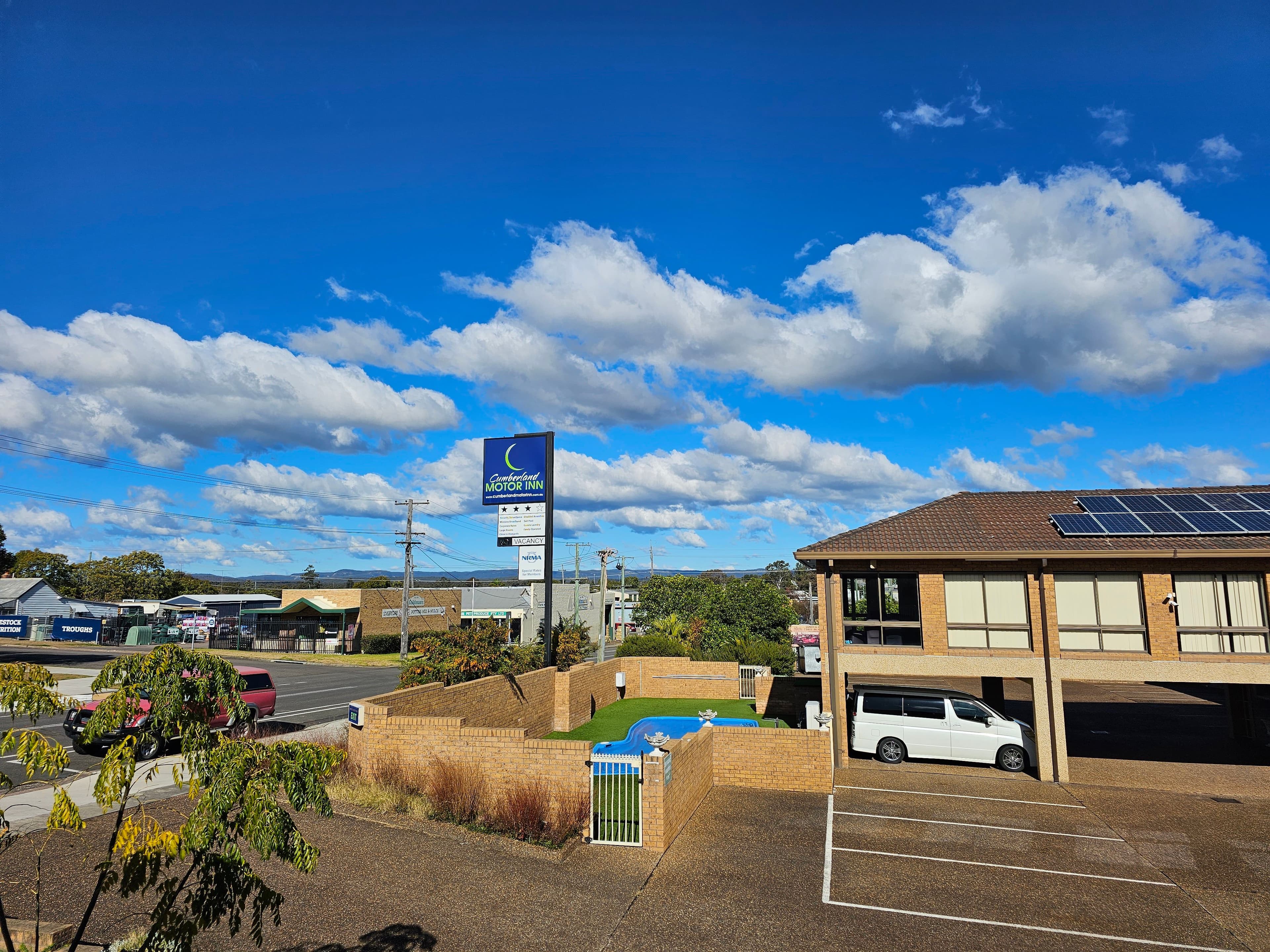 Panoramic view of Cumberland Motor Inn grounds, outdoor pool and skyline